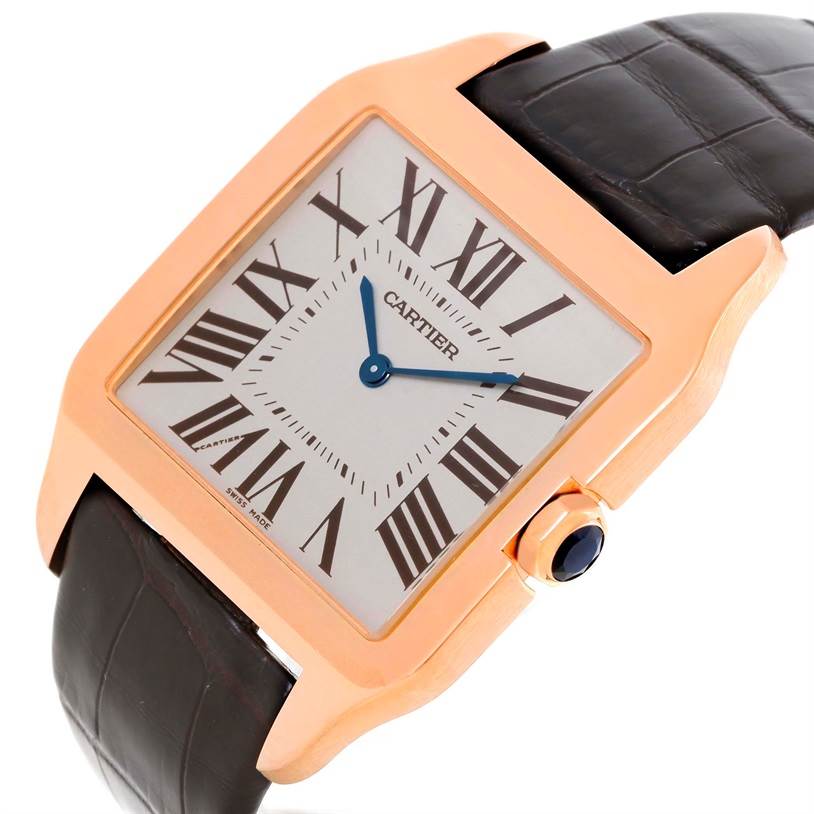 This close-up image of a Cartier Santos Dumont W2006951 Men
s Rose Gold Silver Dial W2006951 Men
s Rose Gold Silver Dial watch shows the square dial, Roman numerals, rose gold bezel, and leather strap.