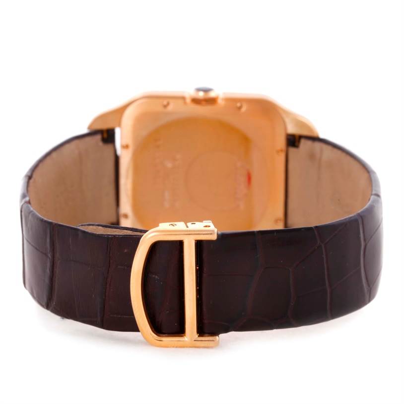 The image shows the back of the Cartier Santos Dumont W2006951 Men
s Rose Gold Silver Dial W2006951 Men
s Rose Gold Silver Dial watch with a brown leather strap and gold buckle.