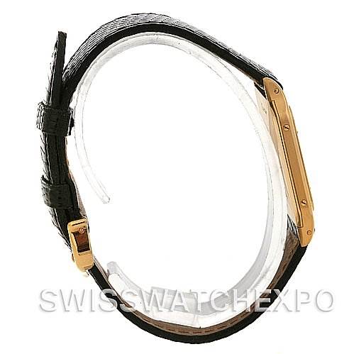 The image shows a side view of a Cartier Santos Dumont Yellow Gold White Dial Yellow Gold White Dial watch, highlighting its thin profile, gold case, and black leather strap.