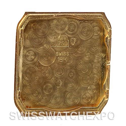This image shows the inside case back of a Cartier Santos Dumont Yellow Gold White Dial Yellow Gold White Dial watch, displaying the Swiss "18K" gold mark.