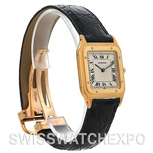 The image shows a side angle of the Cartier Santos Dumont Yellow Gold White Dial Yellow Gold White Dial watch, highlighting its square face, leather strap, and gold buckle.