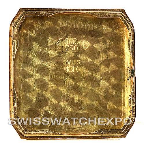 The image shows the inner case back of a Cartier Santos Dumont Men's Yellow Gold White Dial Men's Yellow Gold White Dial watch, indicating it's made of 18K gold.