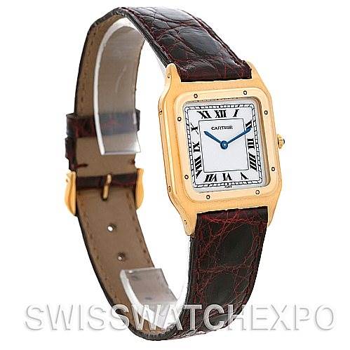 The image shows a Cartier Santos Dumont Men's Yellow Gold White Dial Men's Yellow Gold White Dial watch from an angled front-side view, highlighting the face, leather strap, buckle, and watch crown.