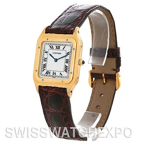 The image shows a Cartier Santos Dumont Men's Yellow Gold White Dial Men's Yellow Gold White Dial watch from a three-quarter angle, highlighting the dial, case, strap, and the clasp.