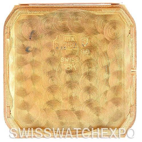 The image shows the interior case back of a Cartier Santos Dumont Men's Yellow Gold White Dial Men's Yellow Gold White Dial watch, displaying its gold hallmark and other inscriptions.