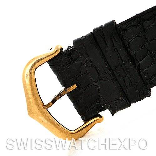 This image shows a close-up of the black leather strap and gold buckle of a Cartier Santos Dumont Men's Yellow Gold White Dial Men's Yellow Gold White Dial watch.