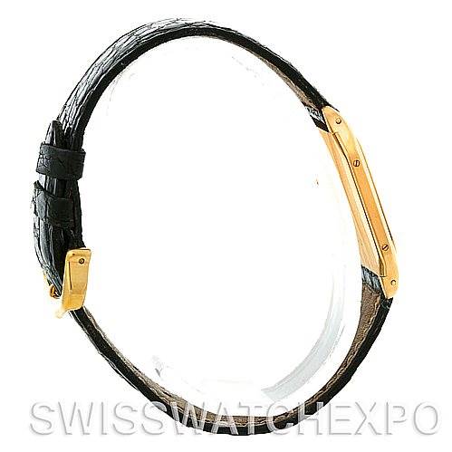 The image shows the side view of a Cartier Santos Dumont Men's Yellow Gold White Dial Men's Yellow Gold White Dial watch, highlighting its slim profile and leather strap, with the case and buckle.