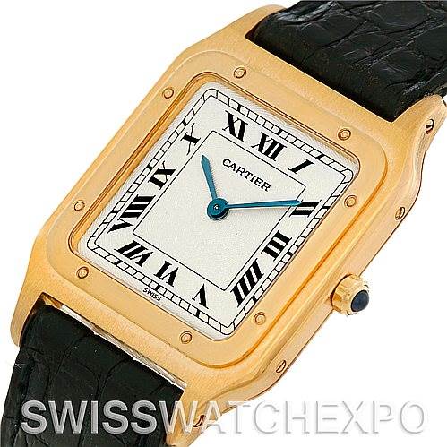 The image shows a close-up of the face and top portion of the strap of a Cartier Santos Dumont Men's Yellow Gold White Dial Men's Yellow Gold White Dial watch, emphasizing its rectangular case and Roman numerals.