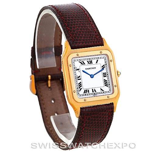 The image shows a Cartier Santos Dumont Men's Yellow Gold White Dial Men's Yellow Gold White Dial model watch at an angle displaying the face, bezel, and leather strap.