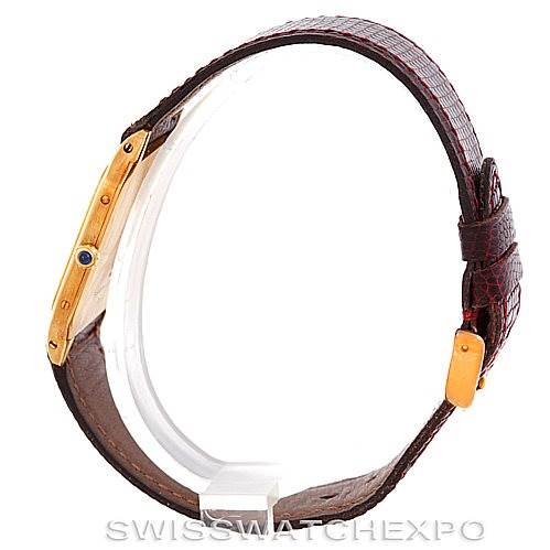 The image shows a side view of the Cartier Santos Dumont Men's Yellow Gold White Dial Men's Yellow Gold White Dial watch, highlighting the gold case and brown leather strap.