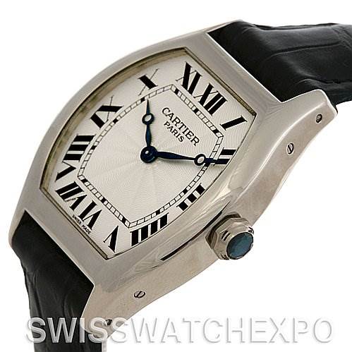 The image shows a close-up angled view of a Cartier Tortue W1546151 Platinum Silver Dial W1546151 Platinum Silver Dial watch, highlighting its dial, Roman numerals, and crown with a blue cabochon.