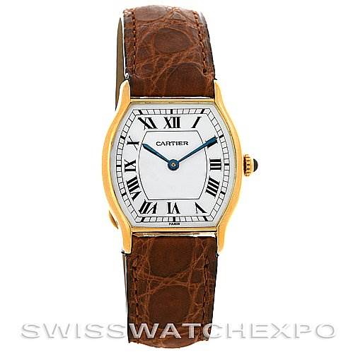 The image shows a front view of a Cartier Tortue Women's Yellow Gold White Dial Women's Yellow Gold White Dial model watch featuring a gold case, white dial with Roman numerals, and a brown leather strap.