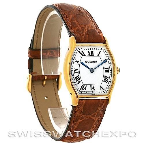 This image shows a Cartier Tortue Women's Yellow Gold White Dial Women's Yellow Gold White Dial watch from a front angle, highlighting its brown leather strap and gold case with Roman numerals.