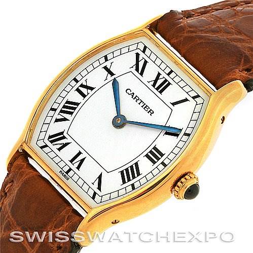 The image shows a Cartier Tortue Women's Yellow Gold White Dial Women's Yellow Gold White Dial watch viewed from an angled close-up, highlighting the face, Roman numerals, and leather strap.