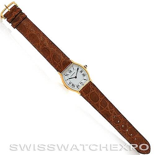 This image shows a top view of a Cartier Tortue Women's Yellow Gold White Dial Women's Yellow Gold White Dial watch with a brown leather strap and a gold case.