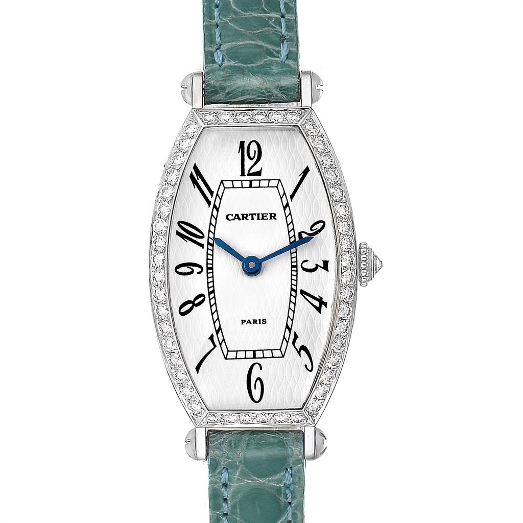 The image shows a Cartier Tortue WE400131 Women's White Gold White Dial WE400131 Women's White Gold White Dial watch with a green strap, oval face, blue hands, and diamond-embellished bezel.