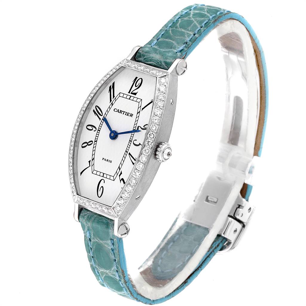 The Cartier Tortue WE400131 Women's White Gold White Dial WE400131 Women's White Gold White Dial watch is shown at a slight angle, displaying its face, diamond bezel, blue hands, and turquoise strap.