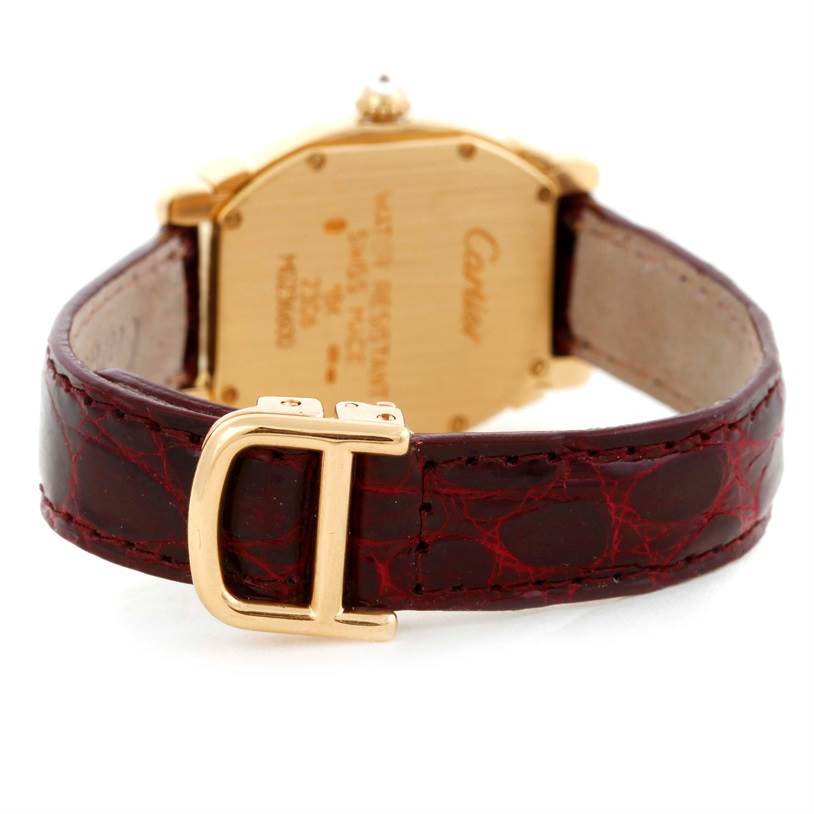 The image shows the back of a Cartier Tortue Women's Yellow Gold Champagne Dial Women's Yellow Gold Champagne Dial watch, featuring its case back, leather strap, and clasp.