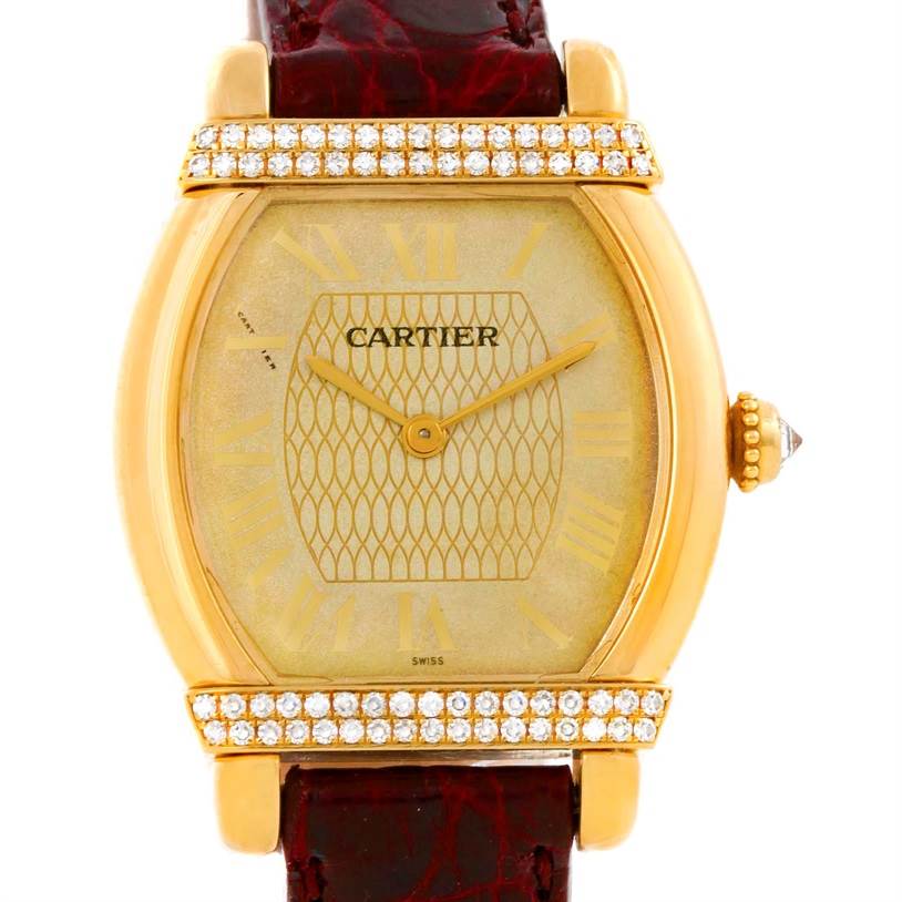 This is a front view of the Cartier Tortue Women's Yellow Gold Champagne Dial Women's Yellow Gold Champagne Dial watch, showing its dial, hands, case, and part of the strap.