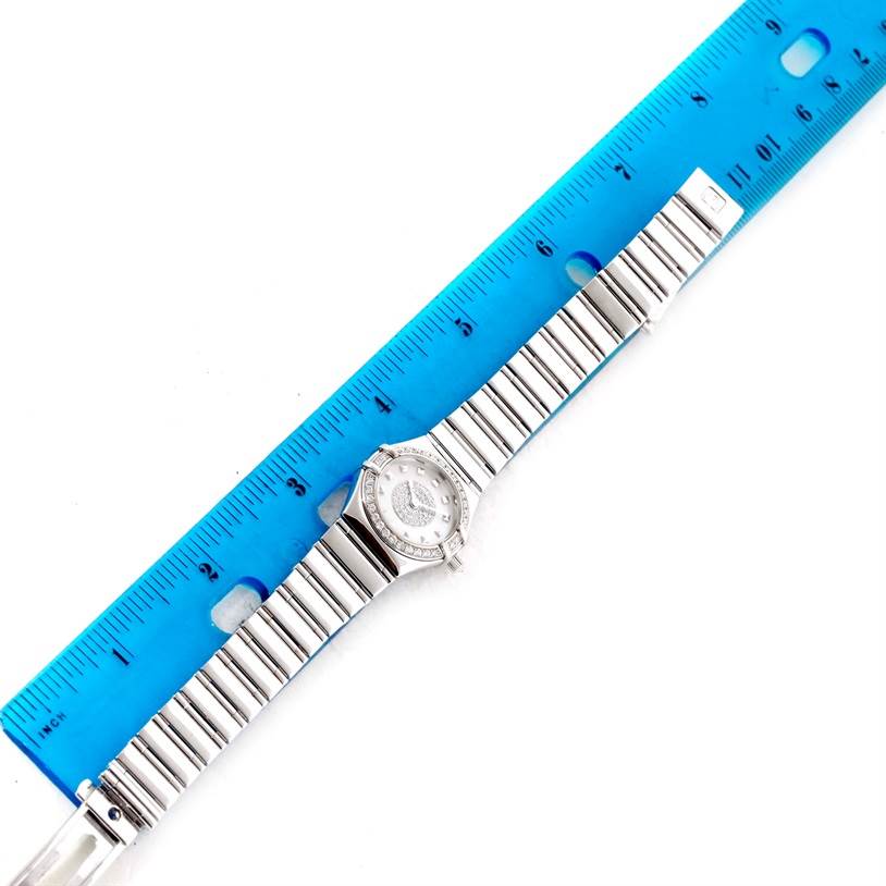 The image shows the Omega Women's White Gold Mother of Pearl Dial Women's White Gold Mother of Pearl Dial Constellation Specialties 18K White Gold Pave Diamond Ladies Watch laid flat with a blue ruler for scale.