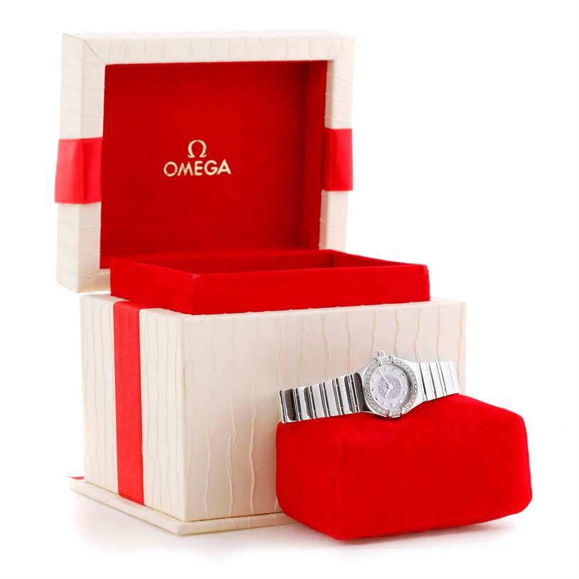 This Omega Women's White Gold Mother of Pearl Dial Women's White Gold Mother of Pearl Dial Constellation Specialties 18K White Gold Pave Diamond Ladies Watch is displayed with its box and cushion at an angled view.