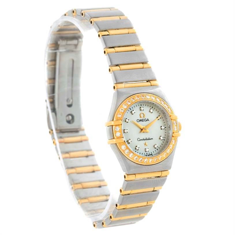 The image shows an Omega 1267.75.00 Women
s Steel and Gold (two tone) Mother of Pearl Dial 1267.75.00 Women
s Steel and Gold (two tone) Mother of Pearl Dial Constellation My Choice Mini 1267.75.00 watch from a side angle, displaying its face, bracelet, and diamond bezel.