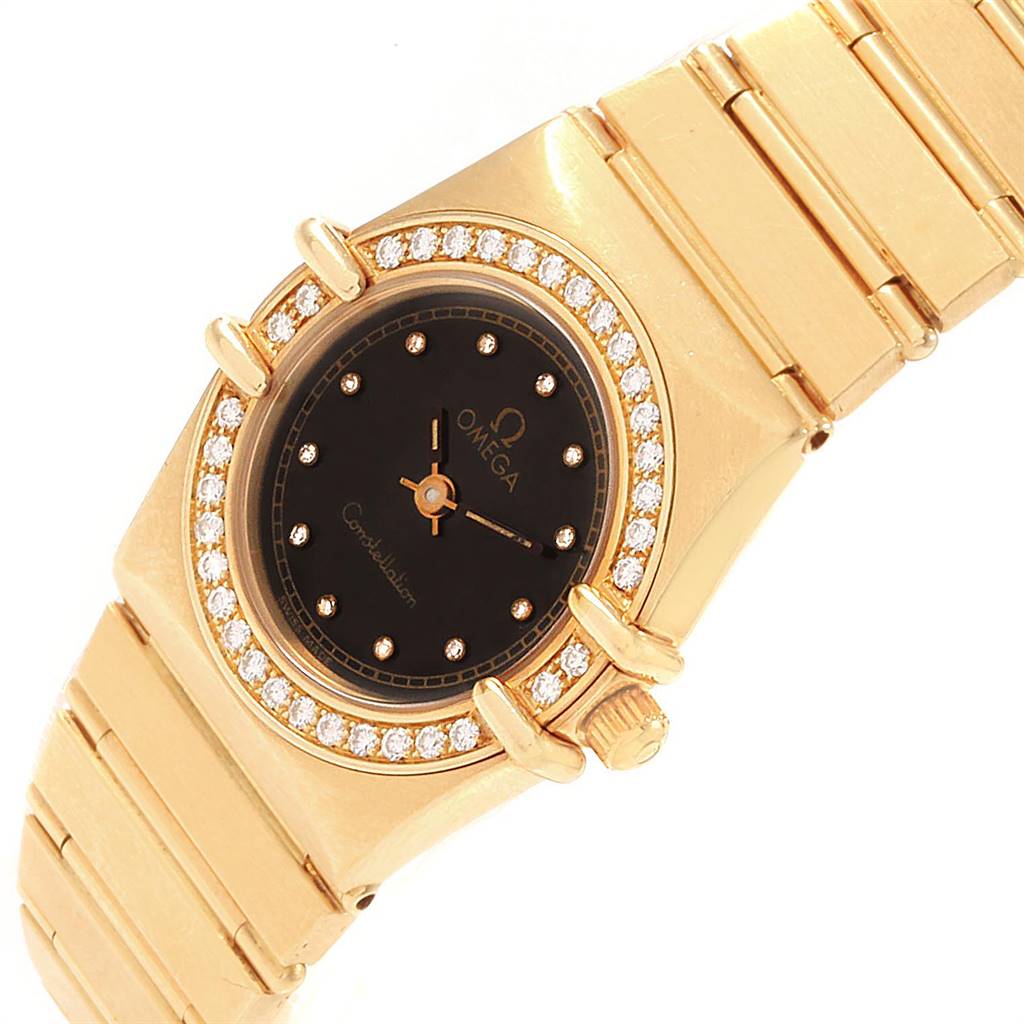 The image displays an angled view of the Omega 1164.75.00 Women's Yellow Gold Black Dial 1164.75.00 Women's Yellow Gold Black Dial Constellation 18K Yellow Gold Diamond Ladies Watch (model 1164.75.00), showcasing the case, dial, and part of the bracelet.