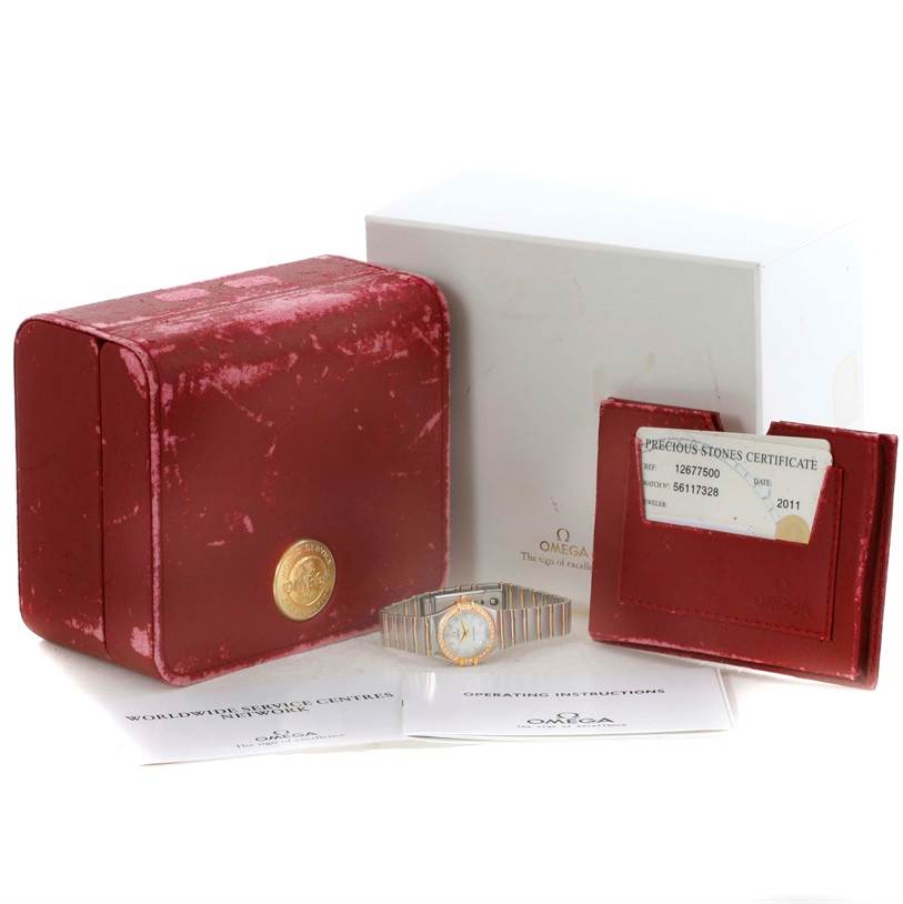 The image shows the Omega 1267.75.00 Women
s Steel and Gold (two tone) Mother of Pearl Dial 1267.75.00 Women
s Steel and Gold (two tone) Mother of Pearl Dial Constellation My Choice Mini Diamond Watch 1267.75.00 with its box, papers, and certificate.