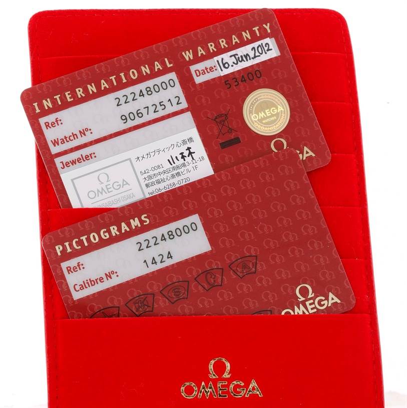 The image shows the warranty and pictogram cards for the Omega 2224.80.00 Women's Stainless Steel Blue Dial 2224.80.00 Women's Stainless Steel Blue Dial Seamaster Professional 300M Ladies Watch 2224.80.00, along with a red cardholder.