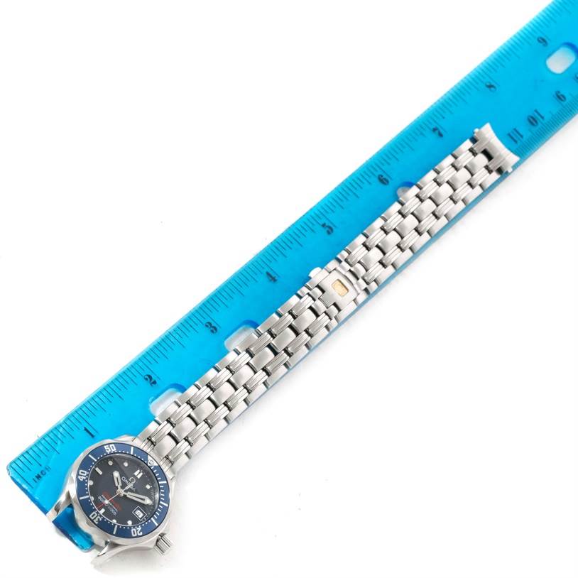 The image shows an Omega 2224.80.00 Women's Stainless Steel Blue Dial 2224.80.00 Women's Stainless Steel Blue Dial Seamaster Professional 300M Ladies Watch model 2224.80.00 laid alongside a blue ruler.