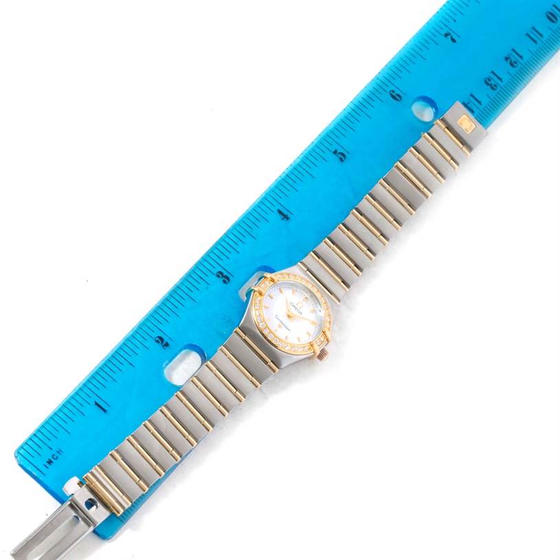 The Omega 1267.70.00 Women
s Steel and Gold (two tone) Mother of Pearl Dial 1267.70.00 Women
s Steel and Gold (two tone) Mother of Pearl Dial Constellation My Choice Mini Steel Gold Diamond Watch 1267.70.00 is shown laid flat with a ruler for scale.
