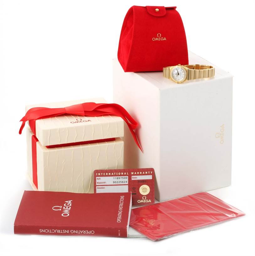 The image shows an Omega 1189.75.00 Women
s Yellow Gold Mother of Pearl Dial 1189.75.00 Women
s Yellow Gold Mother of Pearl Dial Constellation Double Eagle Yellow Gold Diamond Watch 1189.75.00 with its box, pouch, operating instructions, and warranty card.