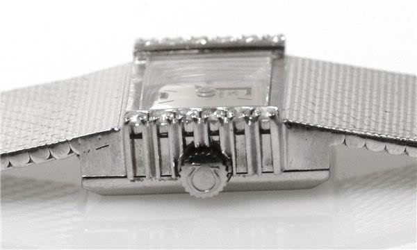 This image shows a side view of the Omega Women's White Gold Silver Dial Women's White Gold Silver Dial Vintage Ladies 18k gold with Diamonds watch, highlighting the crown and part of the band.