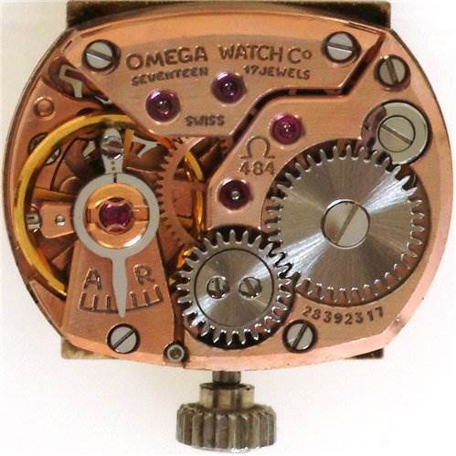 The image shows the internal mechanism of the Omega Women's White Gold Silver Dial Women's White Gold Silver Dial Vintage Ladies 18k Gold with Diamonds watch, highlighting gears and jewels.