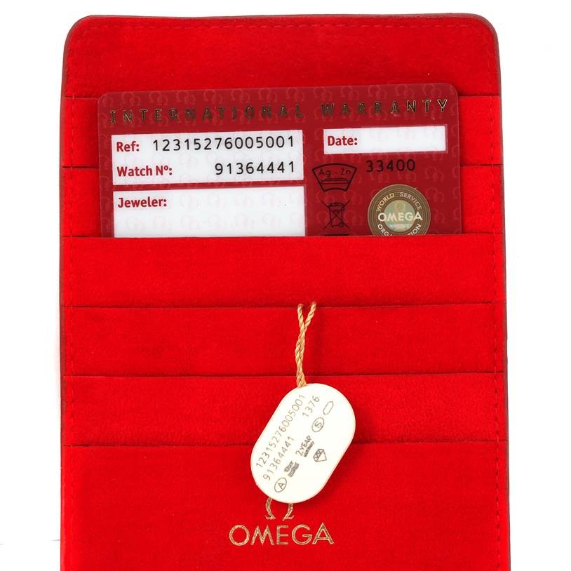 The image shows the warranty card and tag for the Omega 123.15.27.60.05.001 Women
s Stainless Steel Mother of Pearl Dial 123.15.27.60.05.001 Women
s Stainless Steel Mother of Pearl Dial Constellation 27mm Diamond Ladies Watch, model 123.15.27.60.05.001, in a red holder.