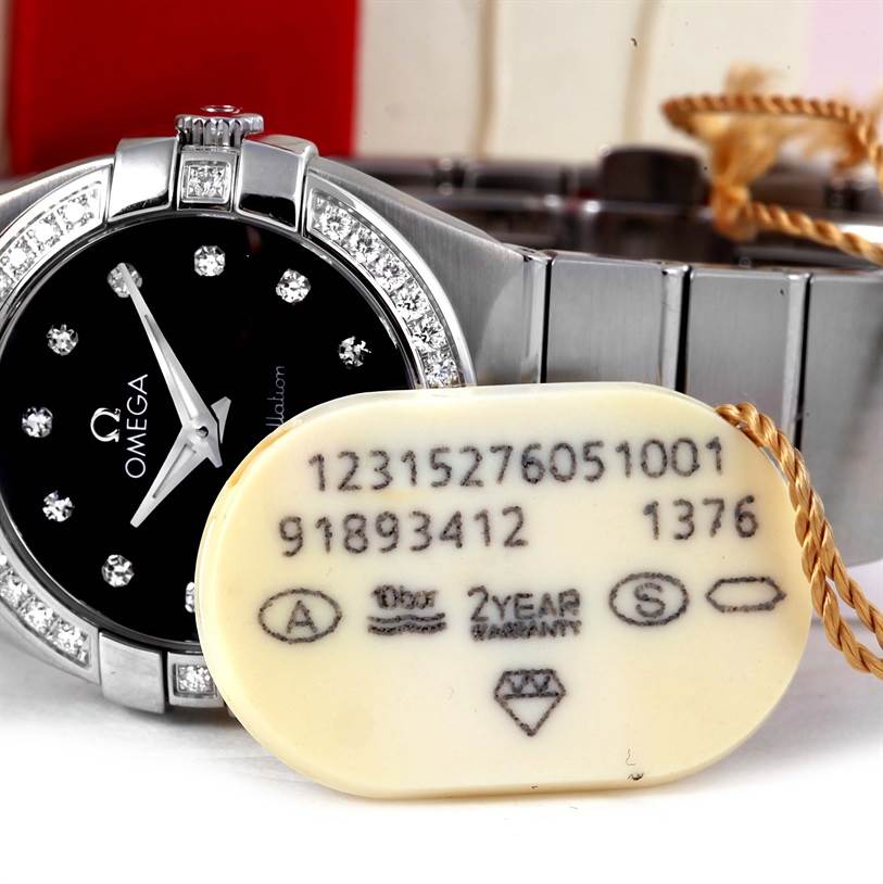 The image shows a close-up of the Omega 123.15.27.60.51.001 Women's Stainless Steel Black Dial 123.15.27.60.51.001 Women's Stainless Steel Black Dial Constellation 27mm Diamond Watch 123.15.27.60.51.001, focusing on the dial and part of the bracelet.