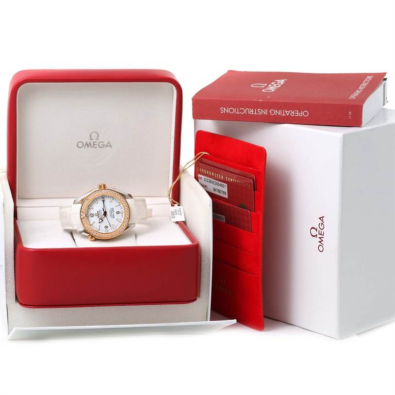 The Omega 222.28.42.20.04.001 Women's Steel and Gold (two tone) White Dial 222.28.42.20.04.001 Women's Steel and Gold (two tone) White Dial Seamaster Planet Ocean 42 mm Diamond Watch 222.28.42.20.04.001 is shown in its box with the operating instructions and certificates.