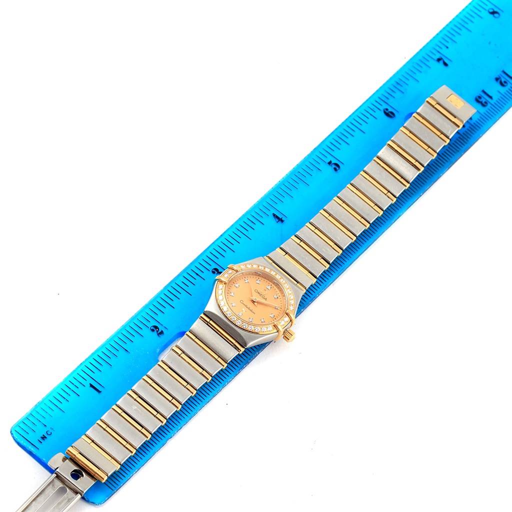 The Omega 1267.15.00 Women
s Steel and Gold (two tone) Champagne Dial 1267.15.00 Women
s Steel and Gold (two tone) Champagne Dial Constellation My Choice Mini Ladies Diamond Watch 1267.15.00 is shown flat with the dial, bracelet, and a ruler for scale.