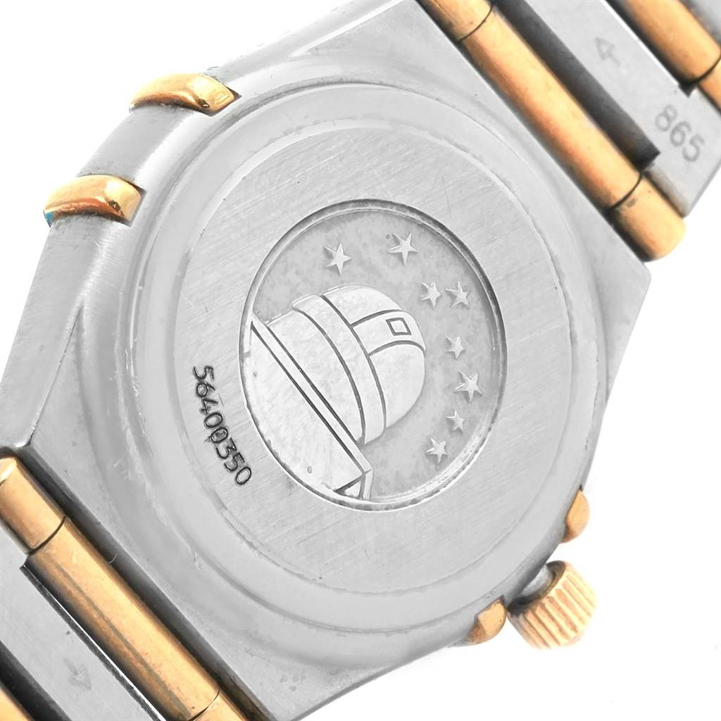 The image shows the case back and part of the bracelet of an Omega 1267.75.00 Women
s Steel and Gold (two tone) Mother of Pearl Dial 1267.75.00 Women
s Steel and Gold (two tone) Mother of Pearl Dial Constellation Mini MOP Diamond Ladies Watch 1267.75.00, featuring an observatory engraving.