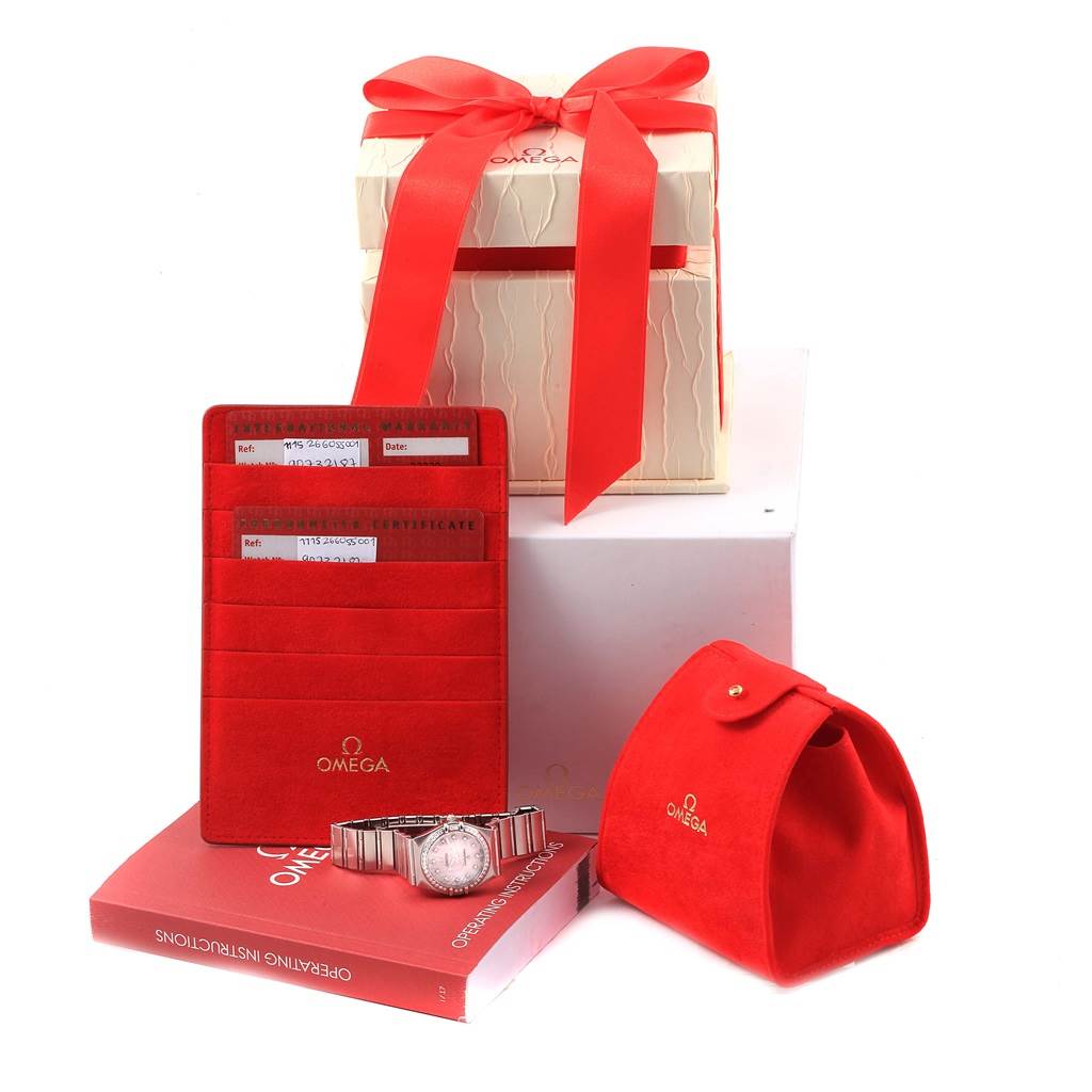 The image shows the Omega 123.15.24.60.55.004 Women's Stainless Steel Mother of Pearl Dial 123.15.24.60.55.004 Women's Stainless Steel Mother of Pearl Dial Constellation MOP Diamonds Ladies Watch model 123.15.24.60.55.004, its box, and associated accessories from a front angle.