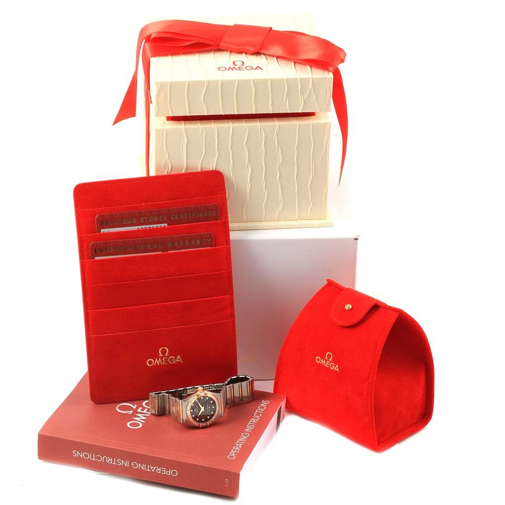 The image shows the Omega 1358.60.00 Women's Steel and Gold (two tone) Brown Dial 1358.60.00 Women's Steel and Gold (two tone) Brown Dial Constellation 95 Steel Rose Gold Diamond Watch 1358.60.00 along with its packaging, case, and documents.