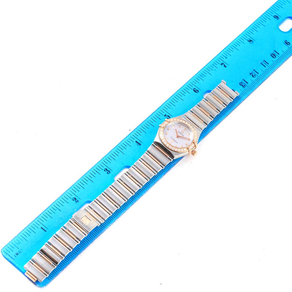 The Omega 1368.71.00 Women's Steel and Gold (two tone) Mother of Pearl Dial 1368.71.00 Women's Steel and Gold (two tone) Mother of Pearl Dial Constellation My Choice MOP Diamond Dial Ladies Watch 1368.71.00 is shown flat against a blue ruler.