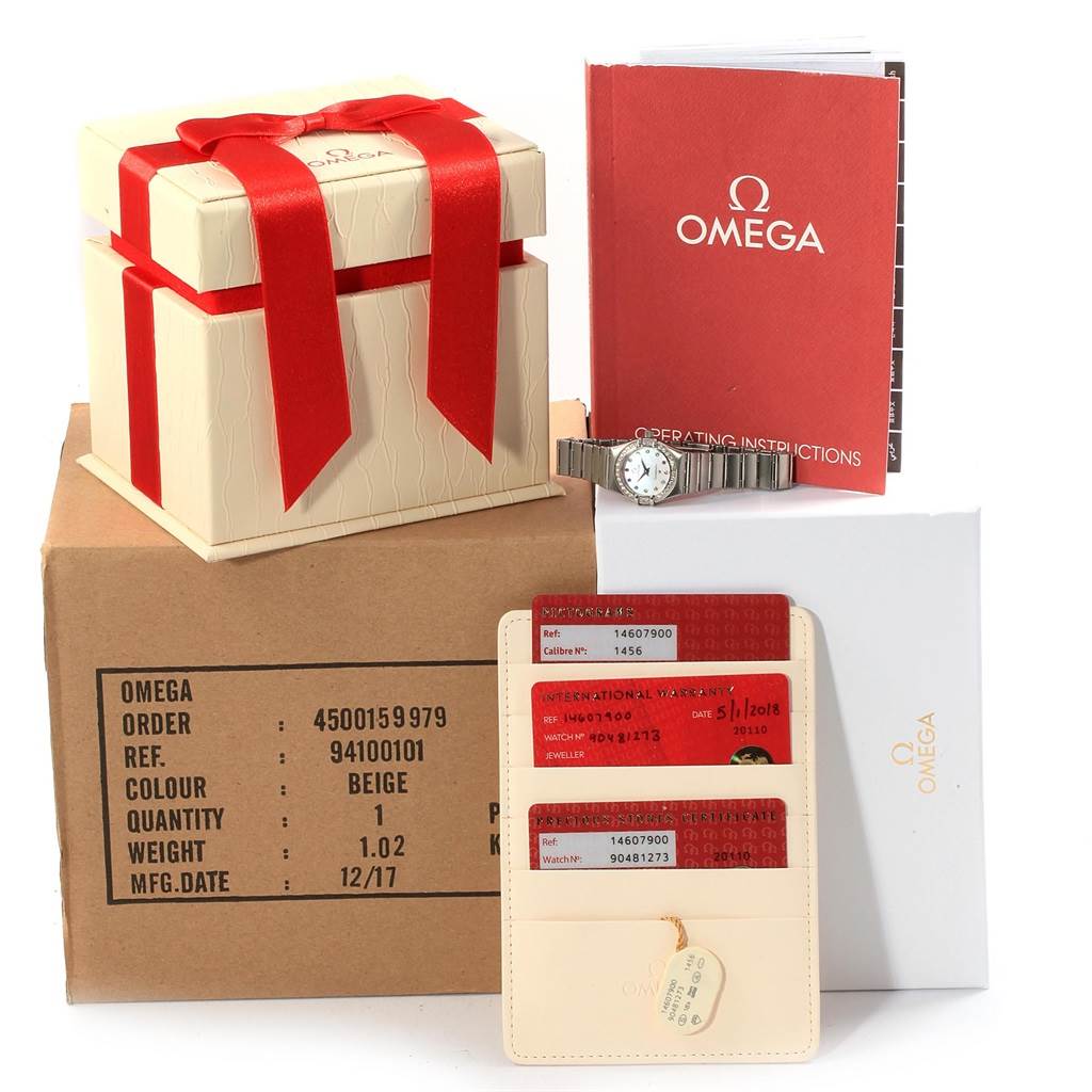 The Omega 1460.79.00 Women's Stainless Steel Mother of Pearl Dial 1460.79.00 Women's Stainless Steel Mother of Pearl Dial Constellation Iris Rainbow Multi Stone Watch 1460.79.00 is displayed with its box, cards, warranty, and instruction manual.