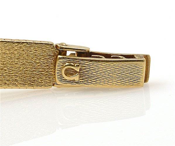 The image shows a close-up of the clasp and part of the band of the Omega 7169 Women's Yellow Gold Champagne Dial 7169 Women's Yellow Gold Champagne Dial Vintage Ladies 18k Yellow Gold 7169 Watch.