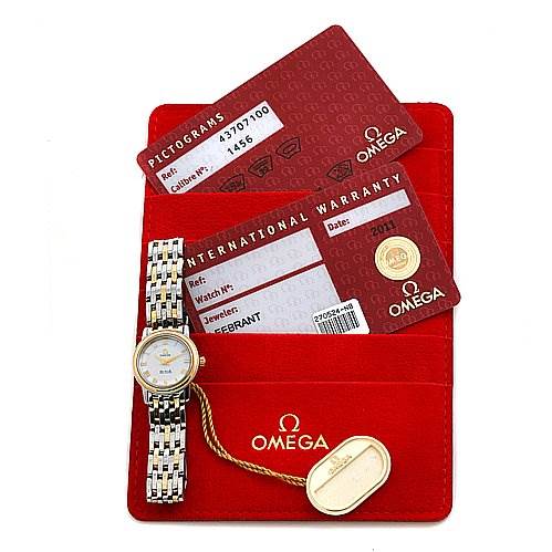 The image shows an Omega 43707100 Women
s Yellow Gold Mother of Pearl Dial 43707100 Women
s Yellow Gold Mother of Pearl Dial De Ville Prestige New Ladies Small Watch (model 43707100) with its warranty card, pictograms card, and a red Omega 43707100 Women
s Yellow Gold Mother of Pearl Dial 43707100 Women
s Yellow Gold Mother of Pearl Dial cardholder.