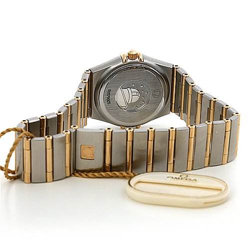 The image shows the back and bracelet of the Omega 12723000 OR 1272.   30.   00 Women's Yellow Gold White Dial 12723000 OR 1272.   30.   00 Women's Yellow Gold White Dial Constellation Small Quartz New Ladies 12723000 Watch, including the clasp and a tag.