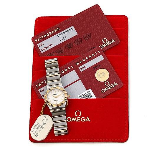 The image shows an Omega 12723000 OR 1272.   30.   00 Women's Yellow Gold White Dial 12723000 OR 1272.   30.   00 Women's Yellow Gold White Dial Constellation Small Quartz New Ladies 12723000 watch laid flat with warranty cards inside a red Omega 12723000 OR 1272.   30.   00 Women's Yellow Gold White Dial 12723000 OR 1272.   30.   00 Women's Yellow Gold White Dial cardholder.