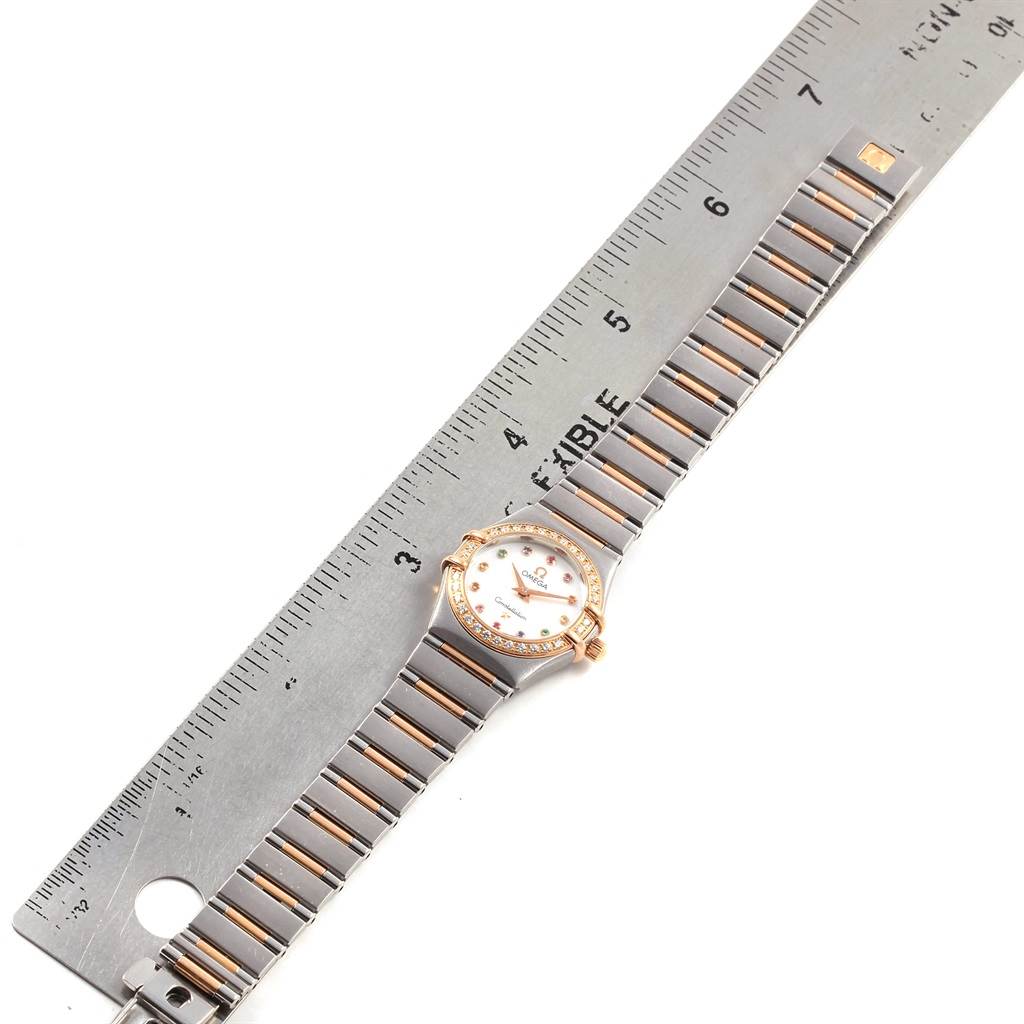 The image shows an Omega 1373.79.00 Women's Steel and Gold (two tone) Mother of Pearl Dial 1373.79.00 Women's Steel and Gold (two tone) Mother of Pearl Dial Constellation Iris My Choice Steel Rose Gold Ladies Watch 1373.79 lying flat next to a ruler.