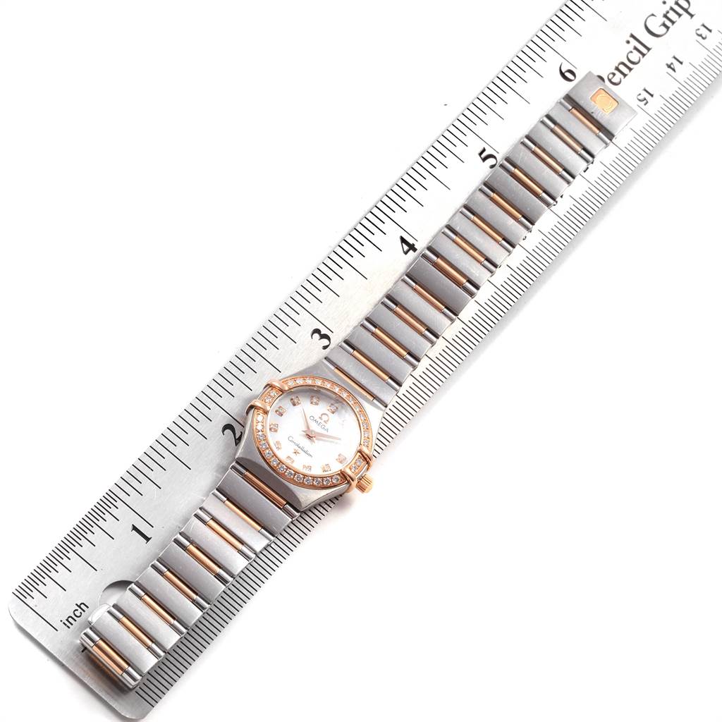The image shows an Omega 1360.75.00 Women's Steel and Gold (two tone) Mother of Pearl Dial 1360.75.00 Women's Steel and Gold (two tone) Mother of Pearl Dial Constellation 95 MOP Diamond Steel Rose Gold Ladies Watch model 1360.75.00 laid flat next to a ruler.