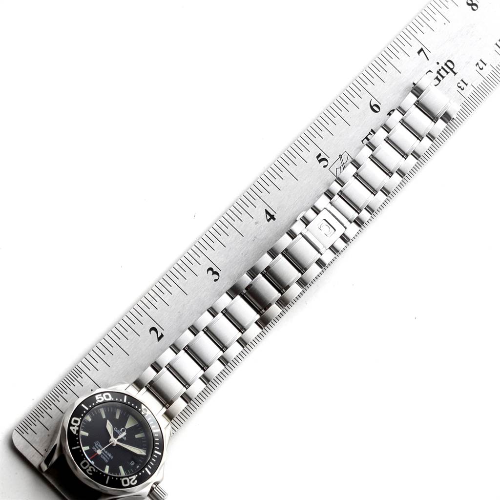 The image shows an Omega 2282.50.00 Women's Stainless Steel Black Dial 2282.50.00 Women's Stainless Steel Black Dial Seamaster Diver 300M Quartz 28mm Steel Ladies Watch 2282.50.00 positioned alongside a ruler, focusing on its face and bracelet.